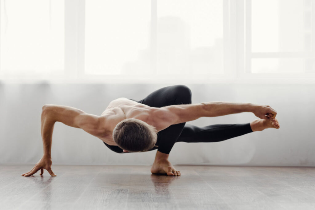 Junger Mann macht eine Übung aus dem Ashtanga-Yoga