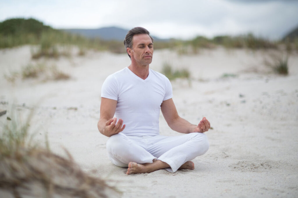 Mann im mittleren Alter führt Meditationsübungen durch