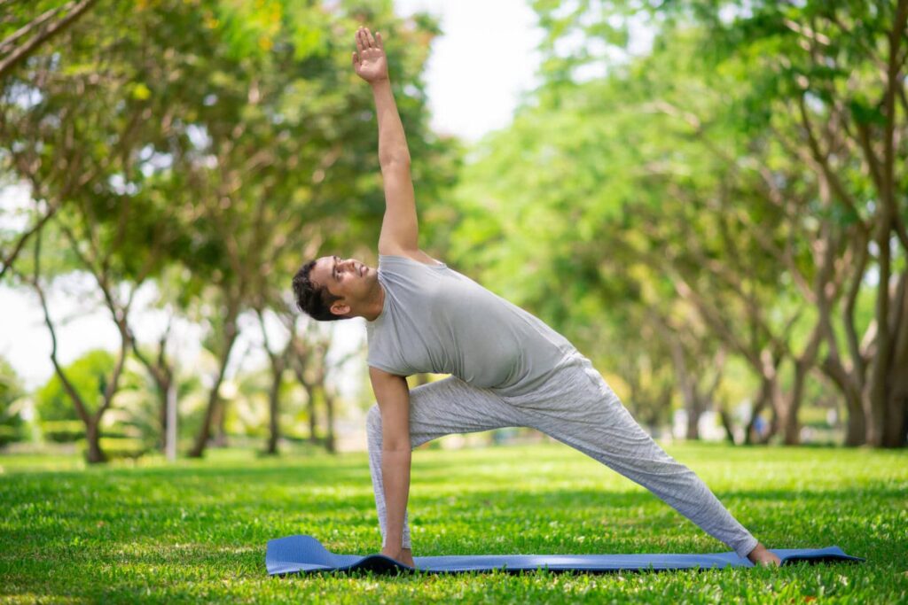 Mann macht Yoga-Übungen in einem Park
