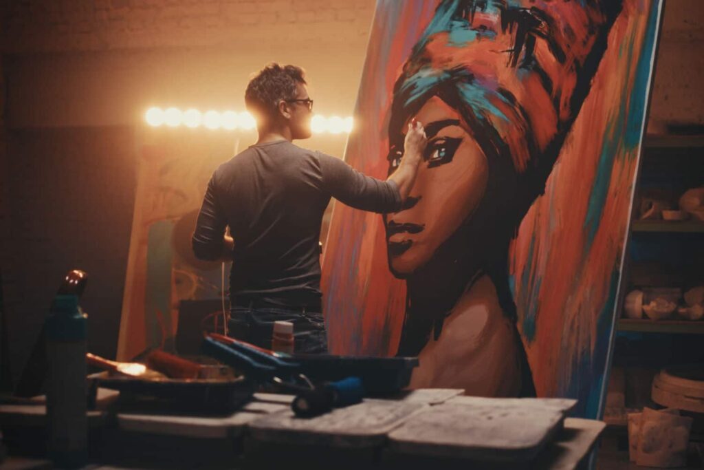 Junger Mann malt ein Porträt einer Frau in einem Atelier