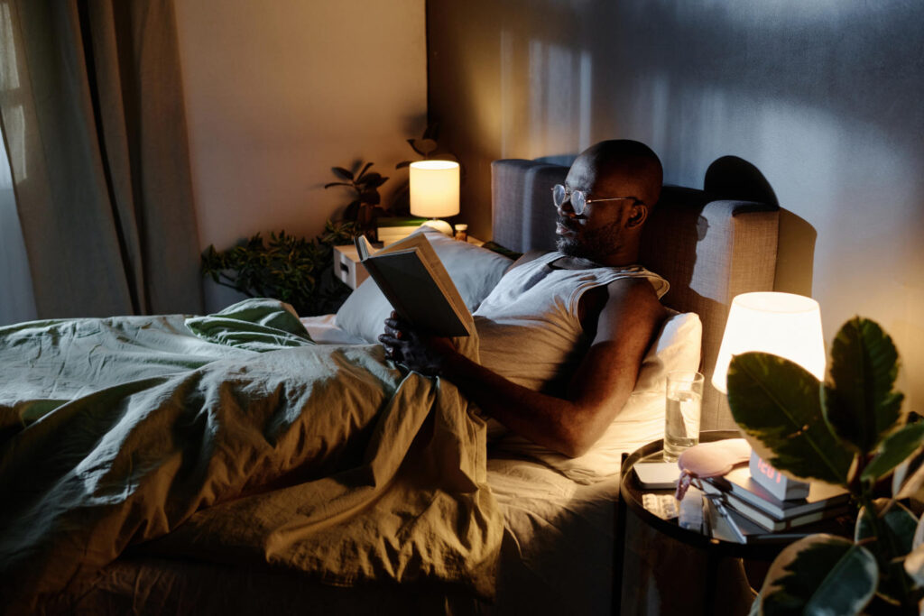 Mann liest abends im Bett